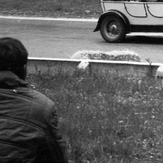 Classic vintage car race on rural road.
