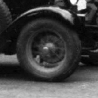 Classic vintage car race on rural road.