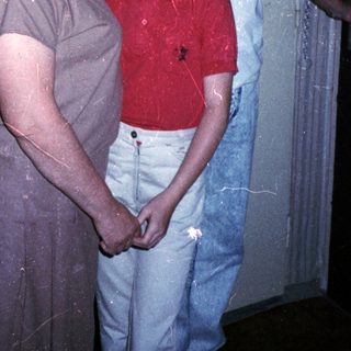 Family members standing indoors near a door.