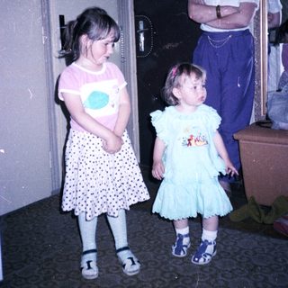 Two young girls with an adult in doorway.
