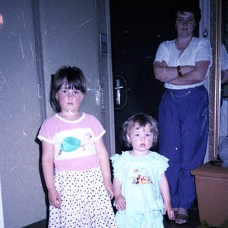Three children and adult standing indoors.