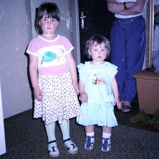 Three children and adult standing indoors.