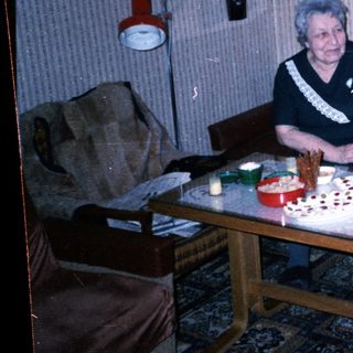 Two people sitting together at a table with birthday cake.