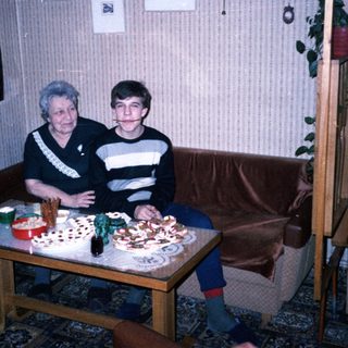 Two people sitting together at a table with birthday cake.