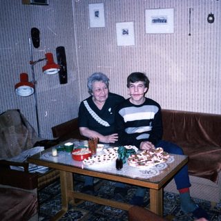 Two people sitting together at a table with birthday cake.