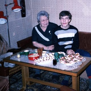 Two people sitting together at a table with birthday cake.