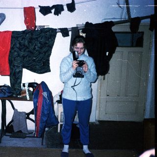 Person taking photo of laundry in indoor drying area.