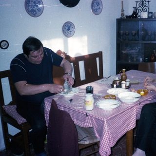 Two people eating breakfast at a vintage table.