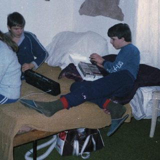 Three people studying together in a dorm room.
