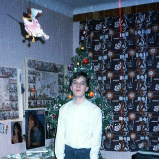Young boy holding gift in festive room.