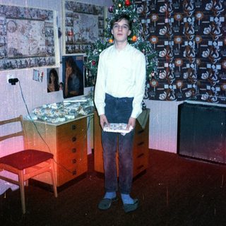 Young boy holding gift in festive room.