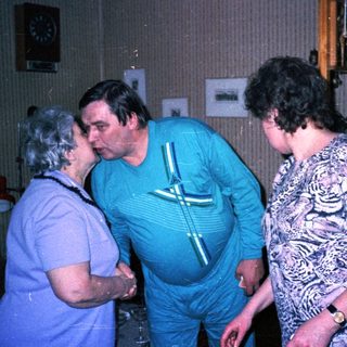 Three people sharing a playful moment indoors.