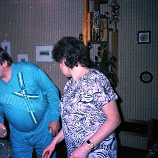 Three people sharing a playful moment indoors.