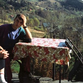 Two people sitting outdoors by a scenic table.