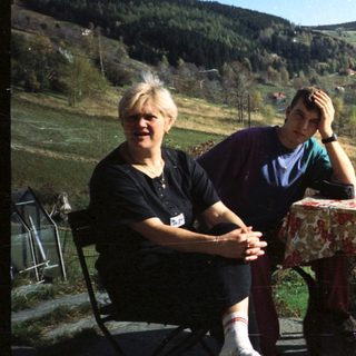 Two people sitting outdoors by a scenic table.