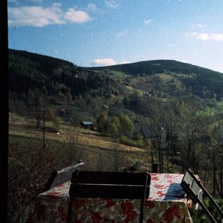 Rural valley scene with rolling hills, forest, and picnic table.