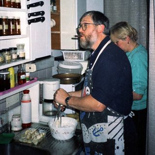 Two people preparing food in a kitchen.