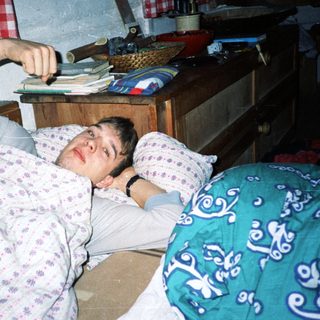 Man lying on bed playing video game.