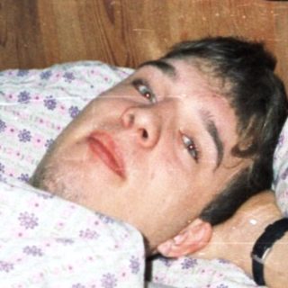 Man lying on bed playing video game.