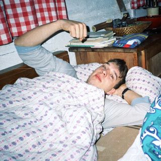 Man lying on bed playing video game.