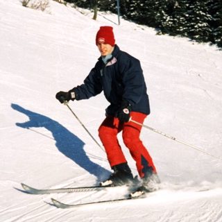Person skiing down snowy slope in winter gear.