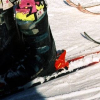 People skiing on snow with a dog.