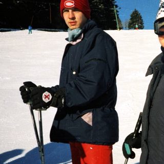 Two people cross-country skiing on snow-covered trail.