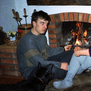 Cozy indoor scene with two people by fireplace.