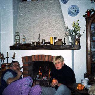 Cozy indoor scene with couple by fireplace.