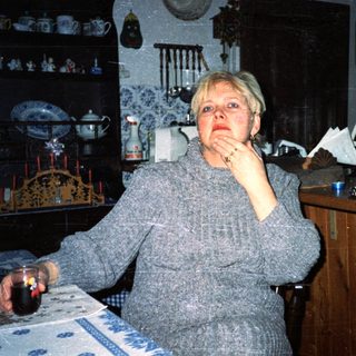 Woman sitting at table with candle, indoors.