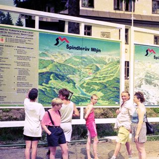 Group of people examining Spindlerův Mýt ski resort maps.