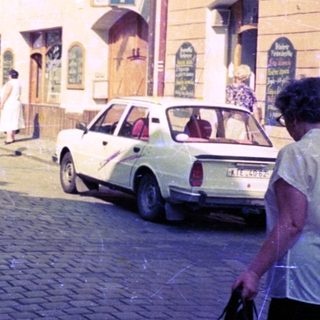 Family posing on cobblestone street in vintage European town.