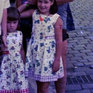 Family posing on cobblestone street in vintage European town.