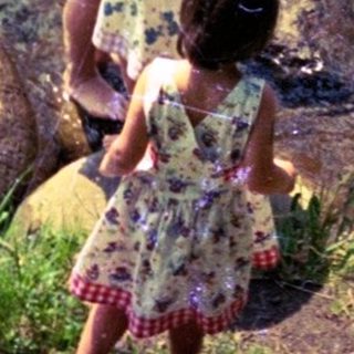 Family enjoying shallow river water near rocks.
