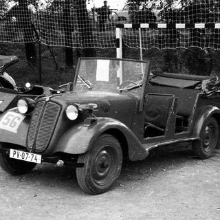Vintage military-style open-top car with license plate.