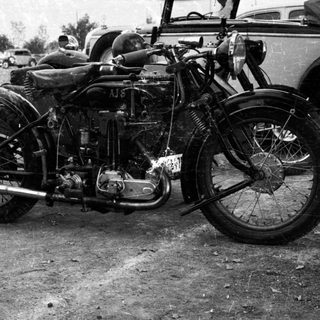 Vintage motorcycle with sidecar components, early 20th century.