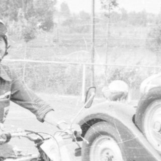 Vintage car and motorcycle parked outdoors.