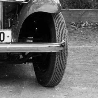 Vintage car BS-52-10 with woman standing nearby.