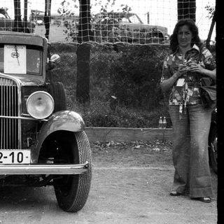 Vintage car BS-52-10 with woman standing nearby.