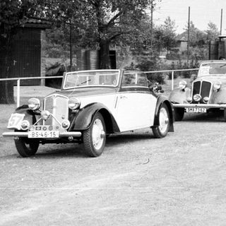 Vintage cars parked in an old roadside area.