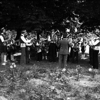 Funeral procession with brass band playing graveside.