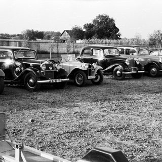 Vintage cars parked in an outdoor lot.