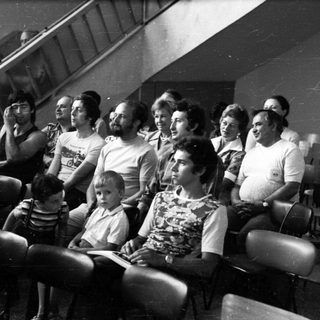 Group of people watching event indoors.