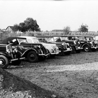 Vintage cars lined up in an outdoor lot.