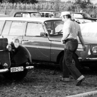 Vintage cars parked in a lot.