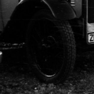 Vintage cars parked in a lot.