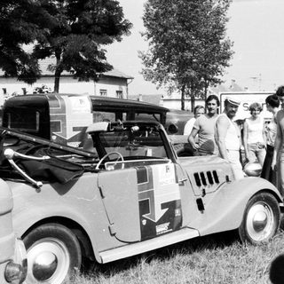 Classic rally car with vintage audience.