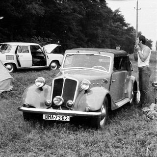 Vintage car with license plate BMA-73-62 being photographed outdoors.