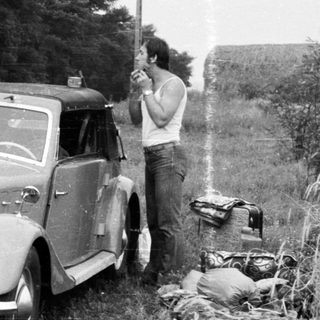 Vintage car with license plate BMA-73-62 being photographed outdoors.