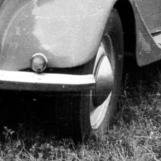 Vintage car with license plate BMA-73-62 being photographed outdoors.